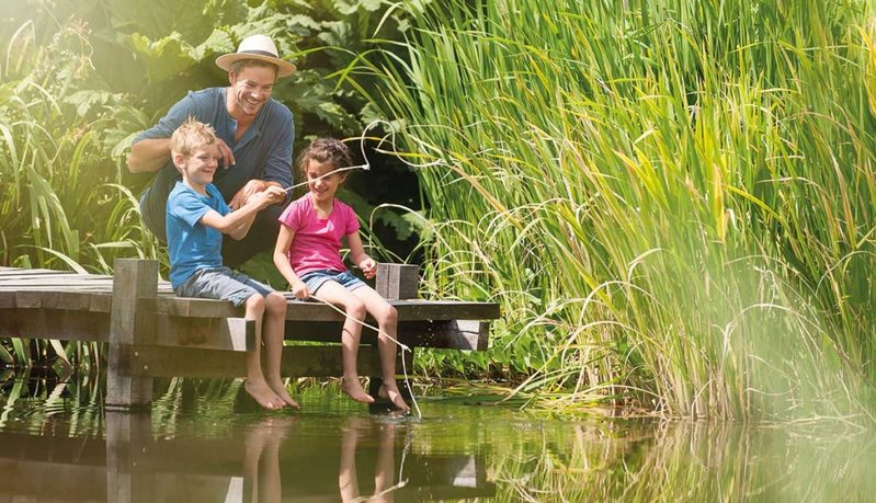 Famille qui pêche au bord d'un lac